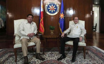 Philippine President Rodrigo Duterte sits beside former President Benigno Aquino Jr.