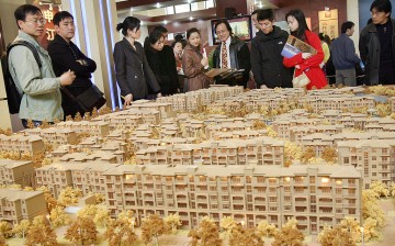 Prospective buyers look at an estate plan by a local developer at a property exhibition in Shanghai.