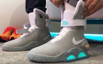 A guy tries on the new self-lacing Nike Mags shoes.