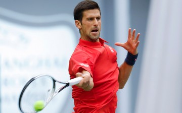 Novak Djokovic hits a tennis ball with great force as he returns it to his opponent.