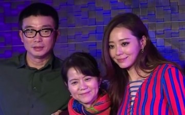 Flanked by Jane Zhang and fiancé Michael Feng, Zhang Guiying smiles before guests as her daughter celebrates her birthday with her fans in Chengdu on Oct. 11.