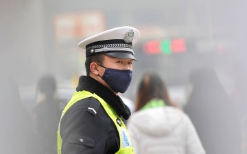 A policeman wears a face mask while directing traffic on Dec. 9, 2015, in Taiyuan, Shanxi Province of China. 