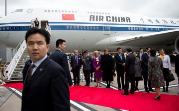 President Xi Jinping and his wife Peng Liyuan greet dignitaries before boarding an Air China plane at Manchester airport at the end of their state visit to Britain on Oct. 23, 2015, in England.