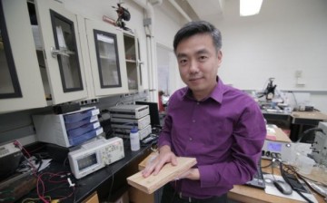 Associate Professor Xudong Wang holds a prototype of the researchers' energy harvesting technology, which uses wood pulp and harnesses nanofibers.