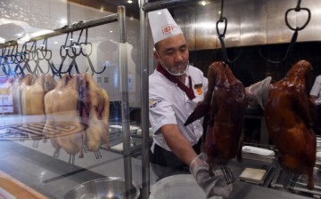 A chef prepares a Peking duck to be served to customers in a Beijing restaurant.