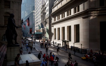 People walk near the New York Stock Exchange on Wall Street.