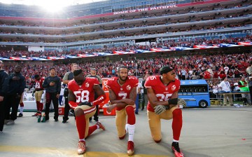 Colin Kaepernick (middle) continues to kneel down during the American national anthem to show his protest to social injustice and police brutality. 