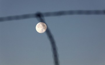 A barbed wire fence stretches along the U.S.-Mexico border as the 'super moon' sets on November 15, 2016 near Arivaca, Arizona. 
