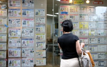 A woman looks at property details in front of a real estate agency on July 10, 2009, in Tokyo, Japan.