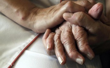 A hand of comfort is laid on baby boomer's hand