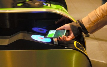 Commuter places iPhone 7 on the card reader to walk through a ticket gate
