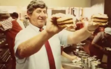 Michael “Jim” Delligatti, Creator of McDonald’s Iconic Big Mac, holding his masterpiece with both hands.