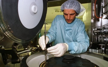 A worker makes adjustments to a production machine in one of Aixtron's facilities.