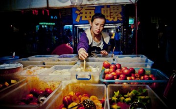 Women empowerment: Millions of women in China became entrepreneurs, thanks to loans granted by the government through local banks. (Above) A fruit stall owner checks on her merchandise.