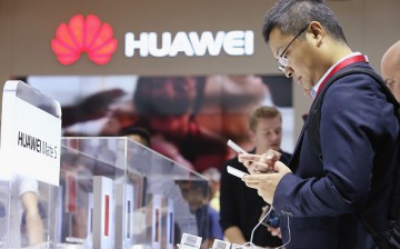 Visitors try out the Huawei Mate S smartphone at the Huawei stand at the 2015 IFA consumer electronics and appliances trade fair on September 4, 2015 in Berlin, Germany.