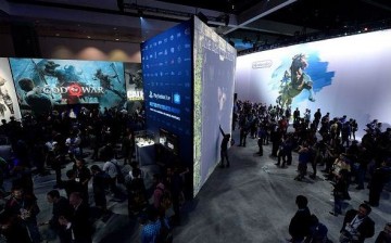 Gamers try out video games in the Sony Playstation booth and wait in line to enter the Nintendo booth to play the new video game 'The Legend of Zelda: Breath of the Wild' during the annual E3 2016 gam