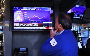 A trader at the New York Stock Exchange monitors the news as the Federal Reserve officials raised interest rates for the first time this year on Dec. 14.