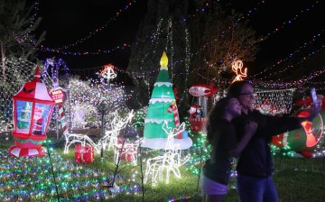 Visitors pose for a selfie as they view the Cambage Court Christmas Lights in the suburb of Davidson after the residents decorated their home and open the yard to visitors in celebration of Christmas.