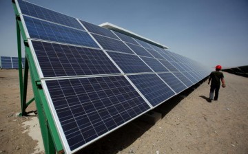 A Chinese worker walks in the solar modules of a newly installed 100MW photovoltaic on-grid power project on July 21, 2010 in Dunhuang of China's northwest Gansu Province. 