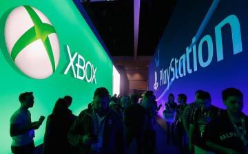Game enthusiasts and industry personnel walk between the Microsoft XBox and the Sony PlayStation exhibits at the Annual Gaming Industry Conference E3 at the Los Angeles Convention Center on June 16, 2015 in Los Angeles, California.
