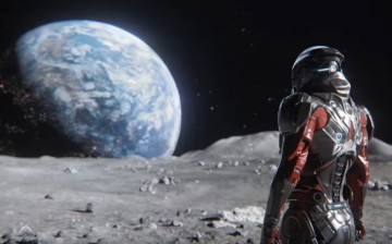 A character from 'Mass Effect: Andromeda' is standing on the surface of the moon, while facing the earth. 
