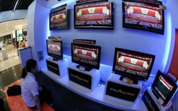 A woman views TV screens showing Chinese President Hu Jintao delivering a speech during the opening ceremony of the 17th CPC National Congress, at a department store on Oct. 15, 2007, in Nanjing.