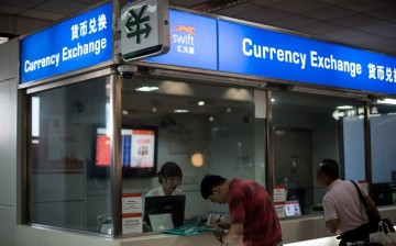 A man changes foreign currency into Chinese yuan at a currency exchange office at Hongqiao airport in Shanghai.
