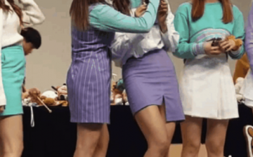 TWICE members, including Tzuyu, on stage during the fan meeting. 