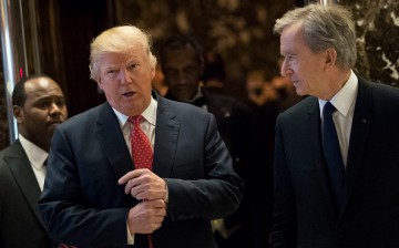 L to R) President-elect Donald Trump and French businessman Bernard Arnault, chief executive officer of LVMH, emerge from the elevators to speak to reporters at Trump Tower, Jan. 9, 2017, in NY.