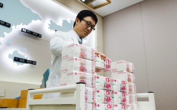 An employee piles bundles of yuan notes in an offshore bank.