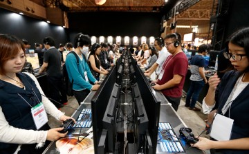 Visitors play a video game on Sony Interactive Entertainment Inc. PlayStation 4 game consoles the Bandai Namco Holdings Inc. booth at the Tokyo Game Show 2016 on September 15, 2016 in Chiba, Japan.