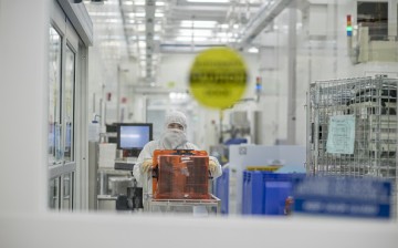 A technician pushes a cart of semiconductor wafers at the Applied Materials Inc. facility in Santa Clara, California.