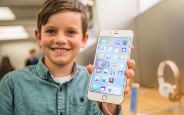 Levi aged 10, shows of the new iPhone 6s Plus in rose gold as crowds wait in anticipation for the release of the iPhone 6s and 6s Plus.