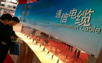 Visitors look at telecommunications cables displayed at an exhibition in Beijing.