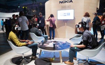 Attendees wear Samsung Gear VR virtual reality headsets to demonstrate the Ozo, a virtual reality camera, manufactured by Nokia Oyj, on the Nokia booth during the Slush startups event in Helsinki, Finland, on Wednesday, Nov. 30, 2016.