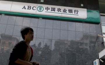 A man walks past the Agricultural Bank of China Ltd., the nation's third-largest lender by market value, as government cracks down on lending to curb loan expansion.