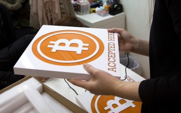 A worker holds a sign at the first bitcoin retail store to open in Hong Kong on Feb. 28, 2014.