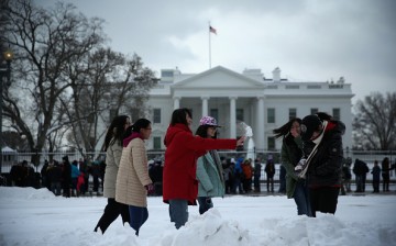 Chinese tourists from Beijing participate in a snowball fight in front of the White House, Feb. 17, 2015, in Washington, DC.