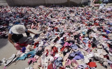 A worker sorts out a huge amount of worn bras at a waste station on Aug. 6, 2014 in Beijing, China. 