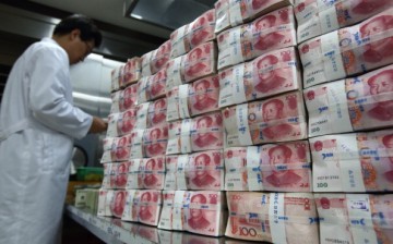 An employee counts 100 yuan banknotes at the Korea Exchange Bank headquarters in Seoul. 
