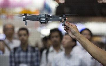 Visitors look at a demonstration of the SZ DJI Technology Co. DJI Mavic Pro drone in the SZ DJI booth at the Combined Exhibition of Advanced Technologies (CEATEC) show.