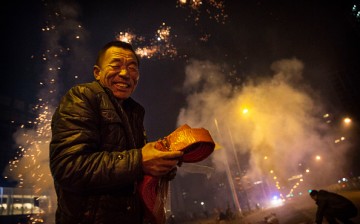 A Chinese man reacts as firecrackers he lit explode during celebrations of the Lunar New early on Feb. 19, 2015 in Beijing, China.