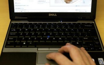 A man uses a laptop displaying a page on its screen of the online auction site Ebay