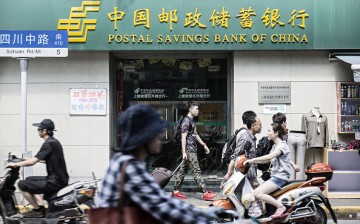 Pedestrians walk past a bank in Shanghai.