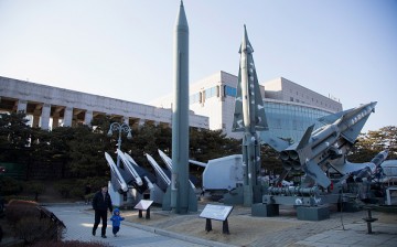 People walk past a display of model missiles including a North Korean Scud-B (C) at the War Memorial of Korea.