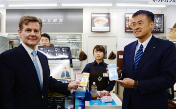 Genichi Tamatsuka (R), CEO of Lawson, and Douglas Feagin (L), senior vice president of Ant Financial Services Group, experience using Alipay at a Lawson convenience store in Tokyo, Japan.
