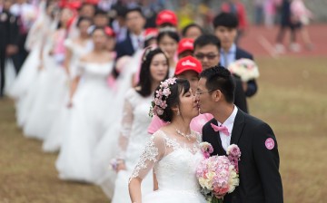 Couples participate in a group wedding ceremony.