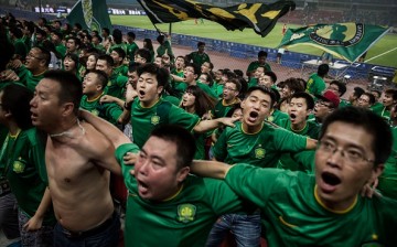 Fans of the Beijing Guoan FC celebrate together after a goal.