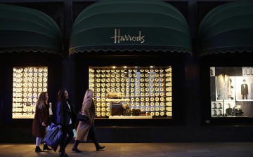 Shoppers walk past Harrods department store.