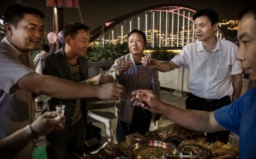 Chinese men toast each other while drinking thier locally made wine called baijiu at dinner on the Chishui River, on Sept. 23, 2016 in Maotai, Guizhou Province, China.